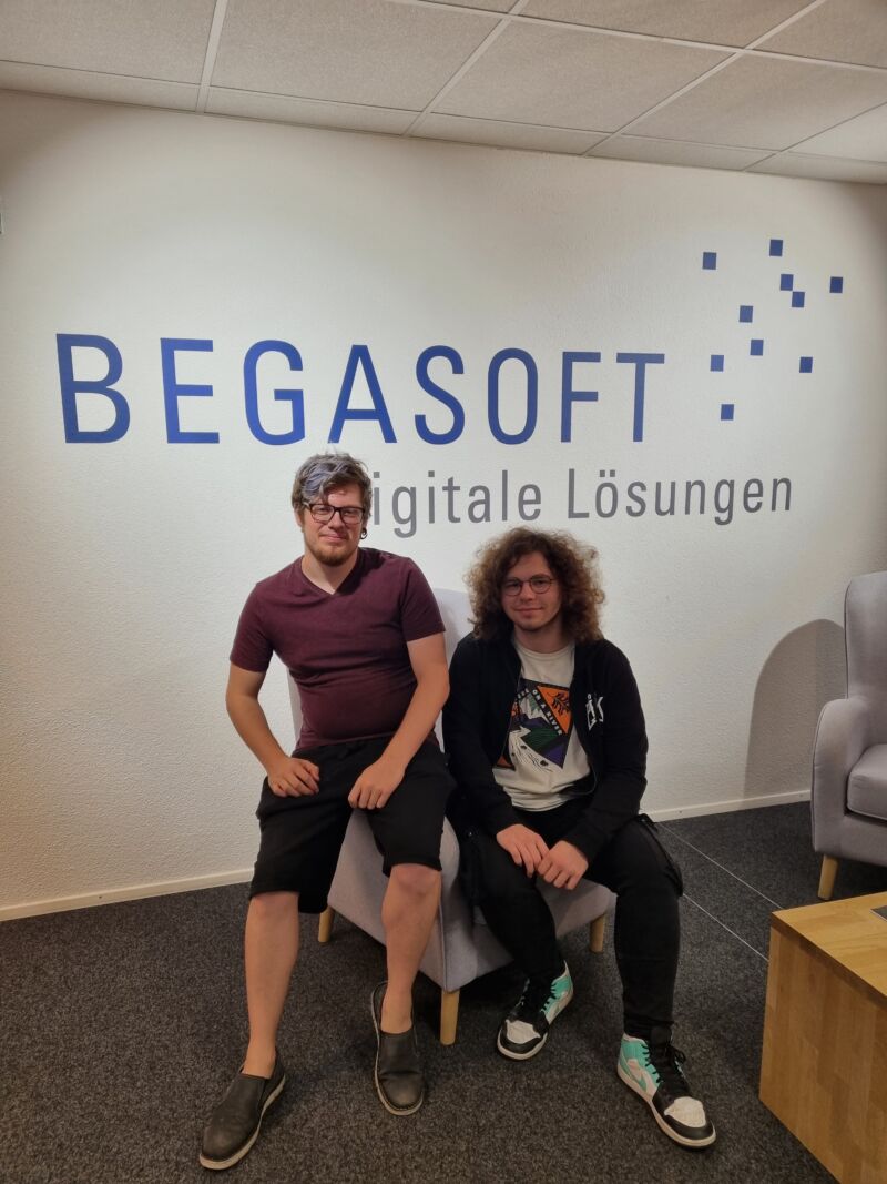 Bild zweier Personen vor dem BEGASOFT Logo